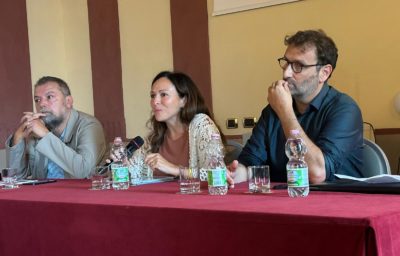 3 people sitting at a red table.